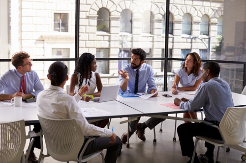 Smartly dressed workers sat around a large meeting table