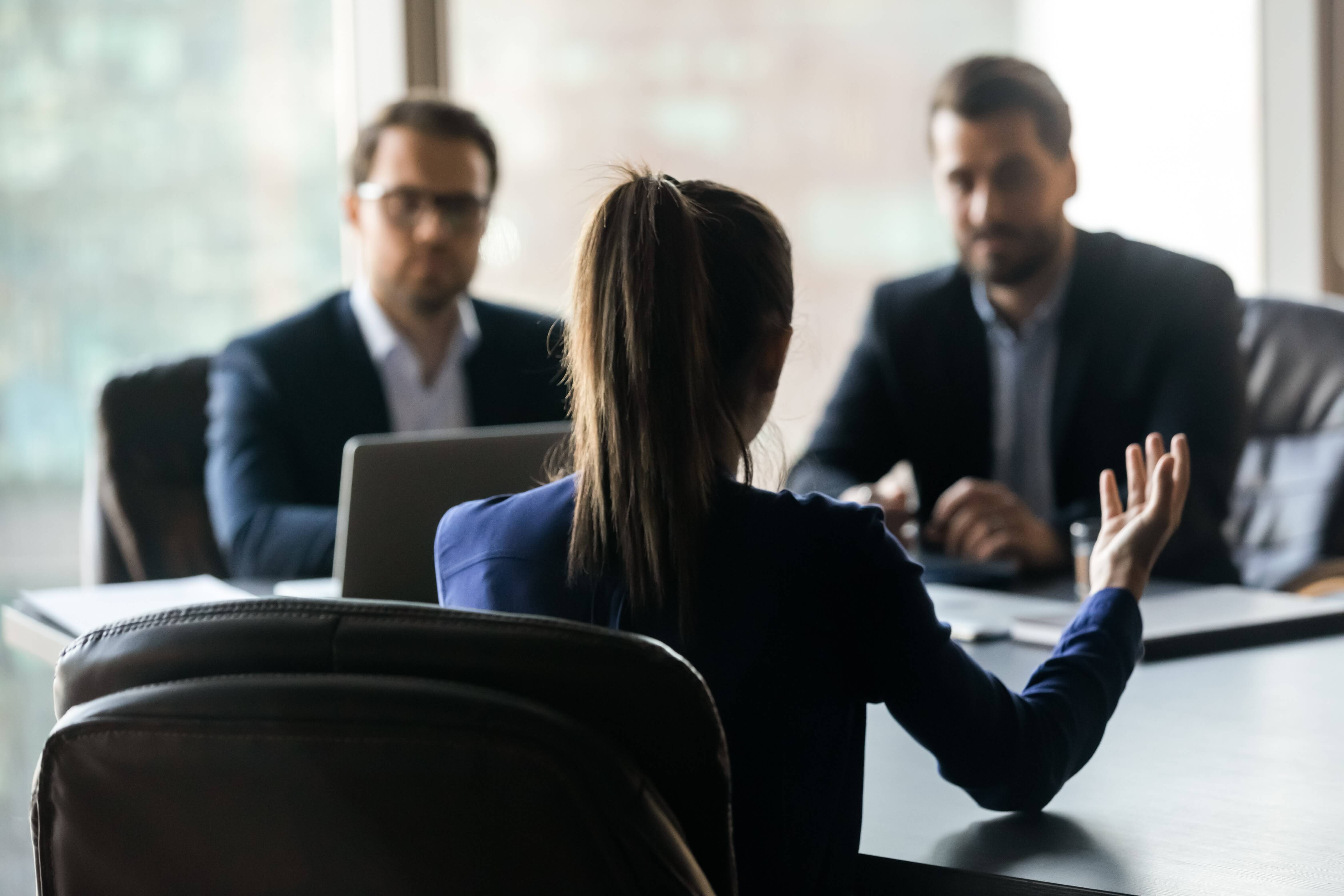 Two men and a woman sat around a table having a conversation