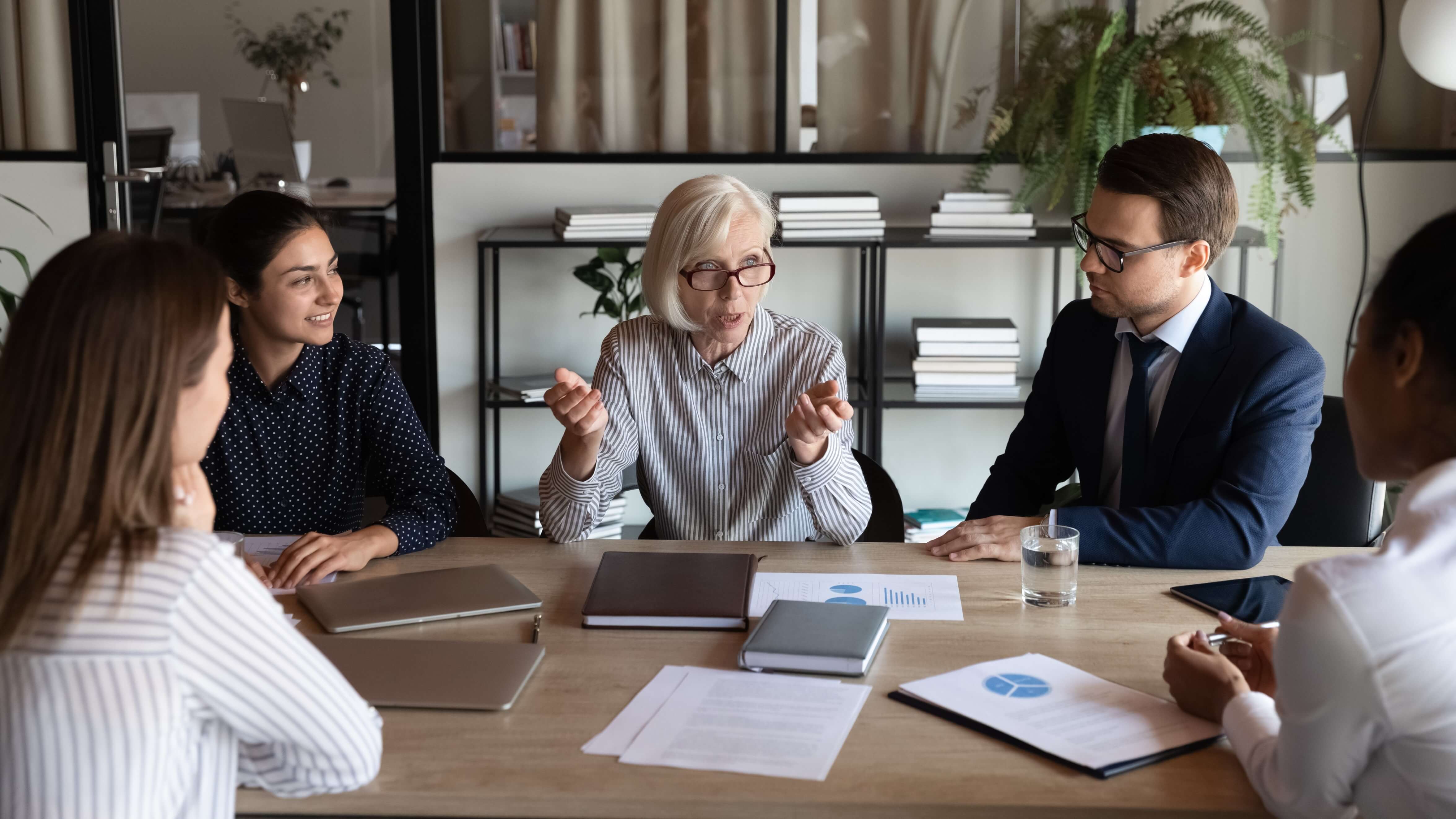 Group of workers talking sat around a table