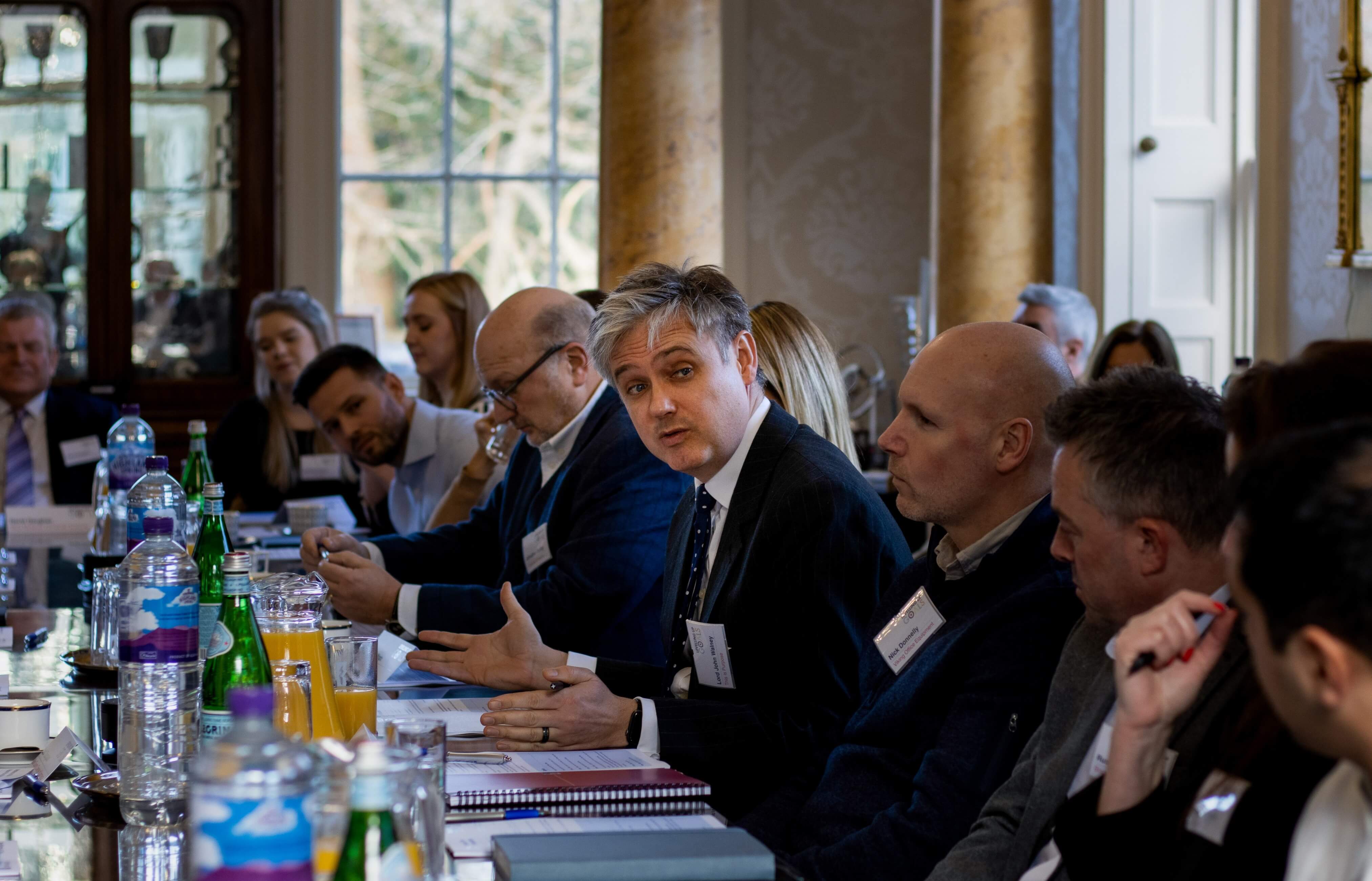 Smartly dressed employees sat at a long meeting table