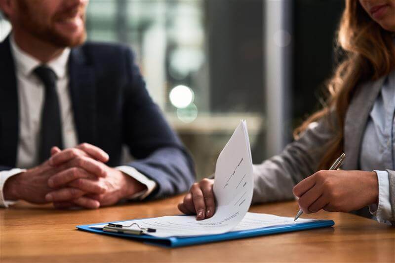 Two people sat at a table reviewing documents