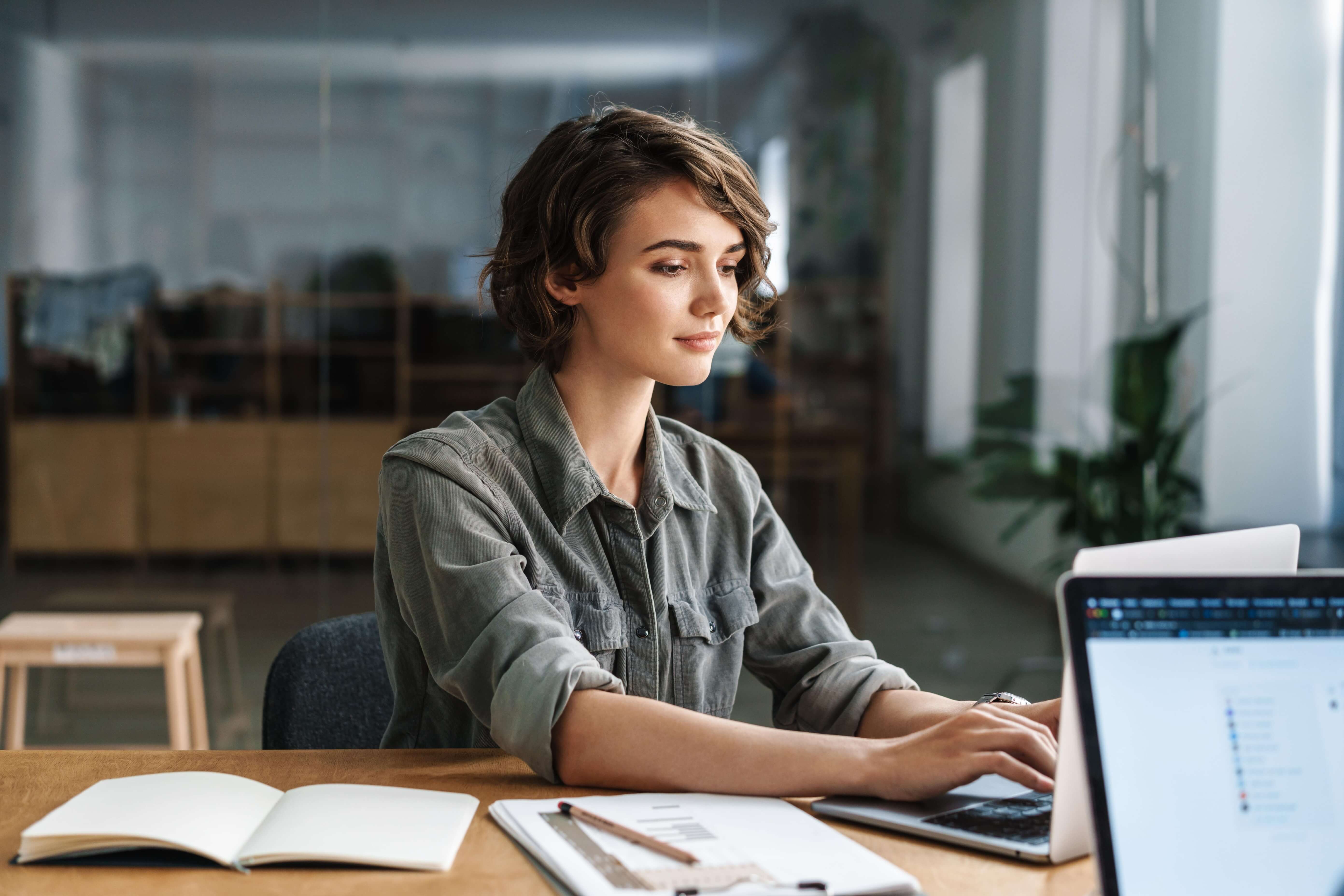 Photograph of a young woman working on at laptop 