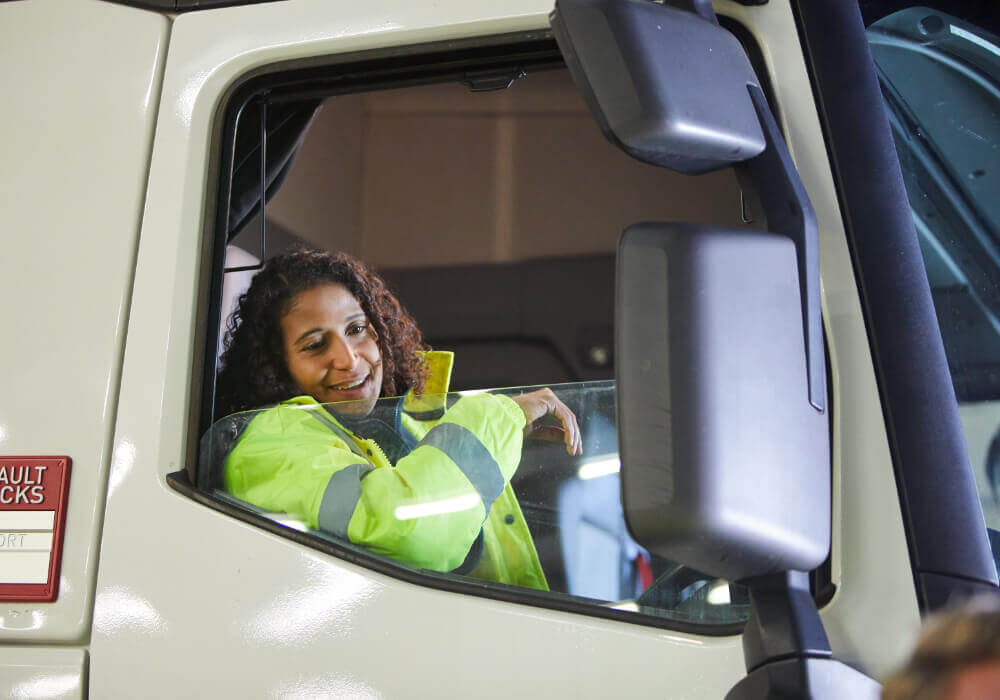 Woman in a hi viz behind the wheel of a lorry