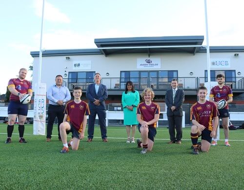 Footballers and Pertemps employees posing on a football pitch