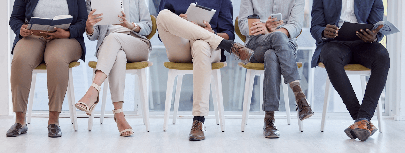 Five interview candidates sat on a row of chairs